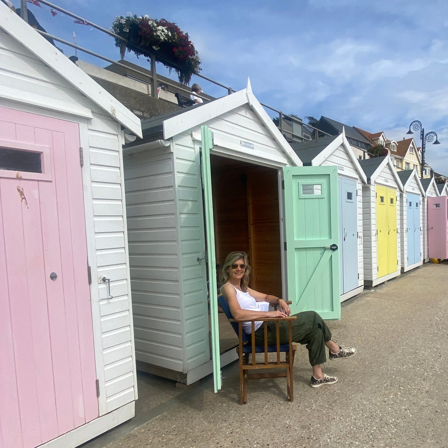 artist sitting by colourful beach huts