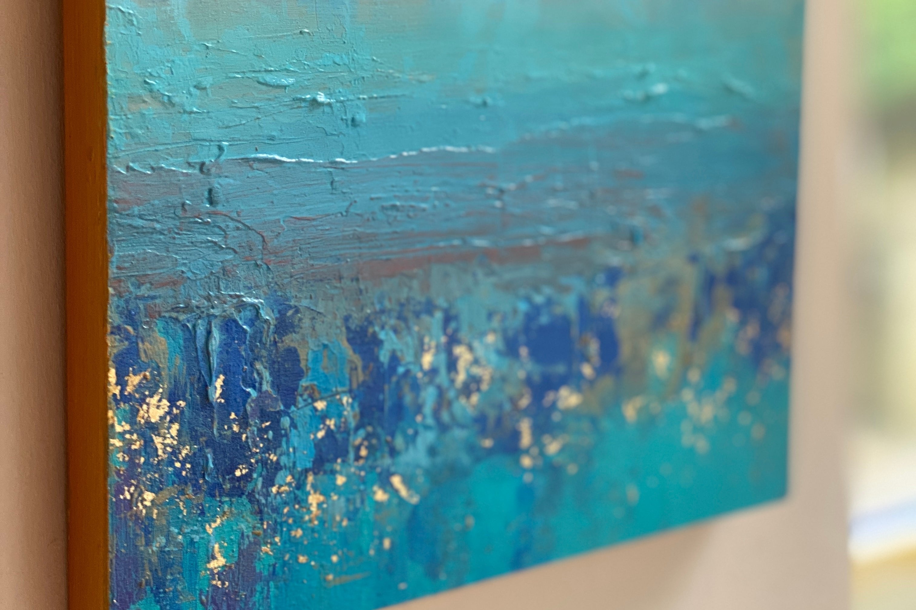 close up of gold and blue seascape painting